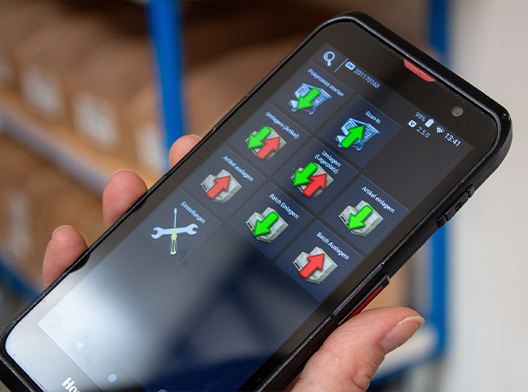 Mitarbeiter erhalten über das Handgerät Anweisungen bei der Kommissionierung.